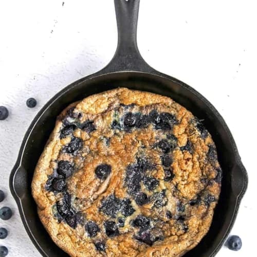 Low Carb Egg strate with Blueberries and Cinnamon in a cast iron pan on a white background