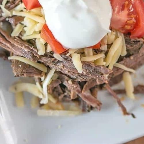 This easy low carb slow cooker shredded beef is a delicious chili lime barbacoa that you can enjoy in a bowl with your favorite toppings or on a tortilla!