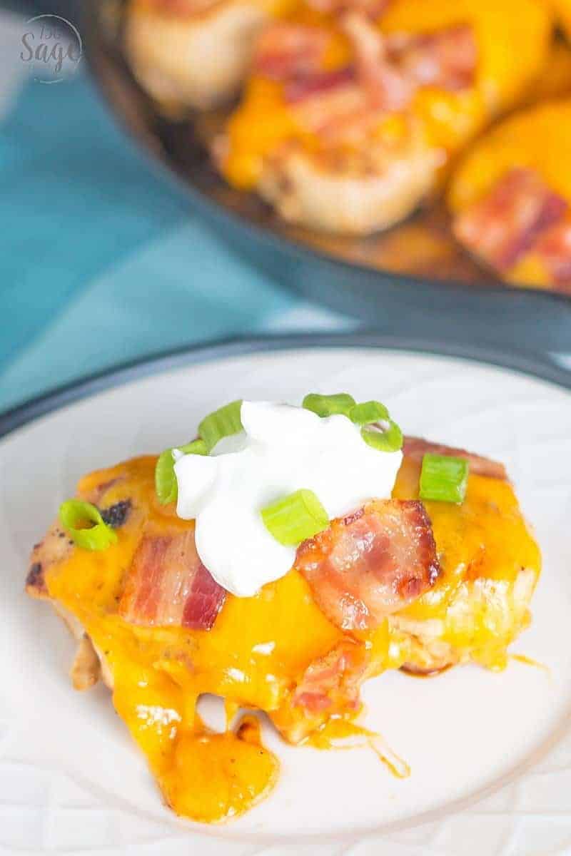 Loaded Low Carb Chicken Recipe #lowcarb #keto #dinner #easy low carb chicken recipe on a white plate with a blue background and a cast iron pan in the background