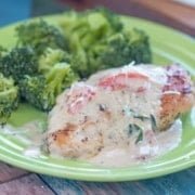 creamy Tuscan chicken on a green plate with a side of broccoli