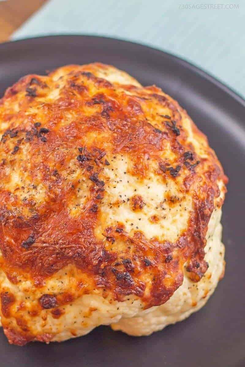 whole roasted cauliflower on a grey plate