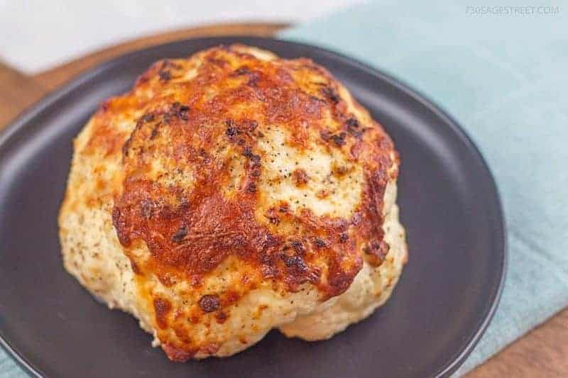 whole roasted cauliflower on a grey plate