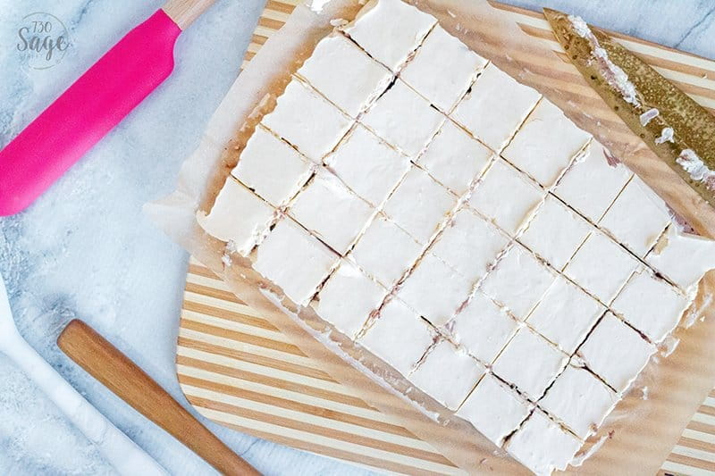 slab of keto fudge cut into pieces on a wooden board