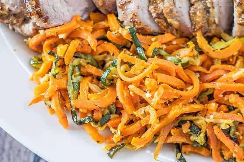 Garlic herb veggie spirals close up of spiral carrots and zucchini on a white plate