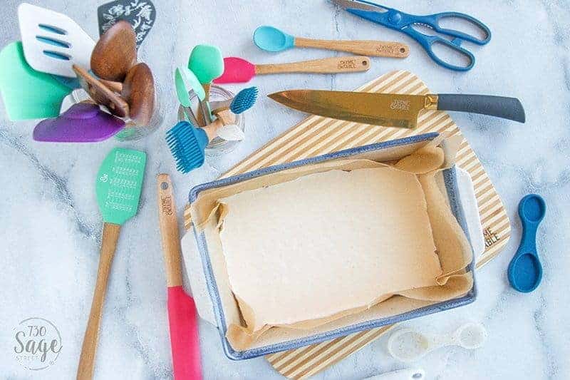 blue dish with white keto fudge surrounded by colorful utensils