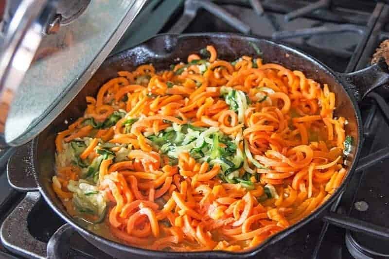 spiral carrots and zucchini saute in a cast iron pan