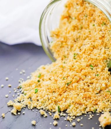low carb breadcrumbs spilling on a grey background in a glass jar