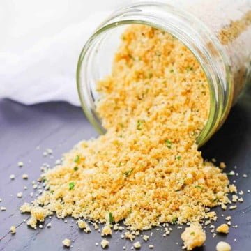 Low Carb Breadcrumbs - Keto Friendly Homemade Breadcrumb Mix 9 low carb breadcrumbs spilling on a grey background in a glass jar