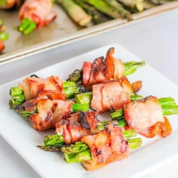 grilled bacon wrapped asparagus on a white plate