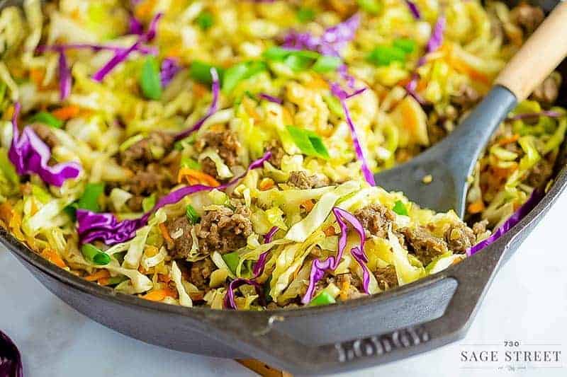 keto egg roll in a bowl recipe being cooked in a cast iron pan