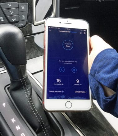 hand holding cellular phone with Hotspot Shield app open on screen