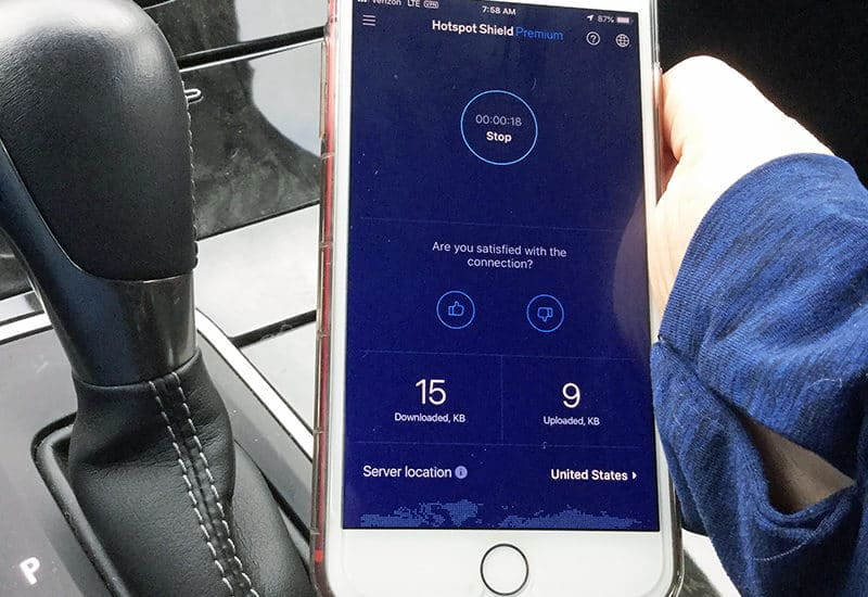 hand holding cellular phone with Hotspot Shield app open on screen
