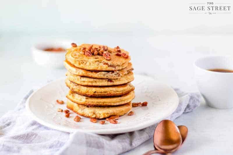 side view keto pancakes made with ricotta cheese on a white plate sprinkled with pecans