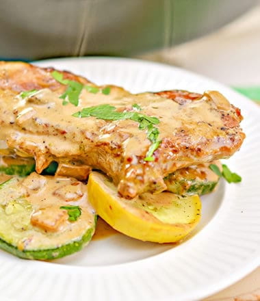 keto mustard pork chops on veggies on a white plate