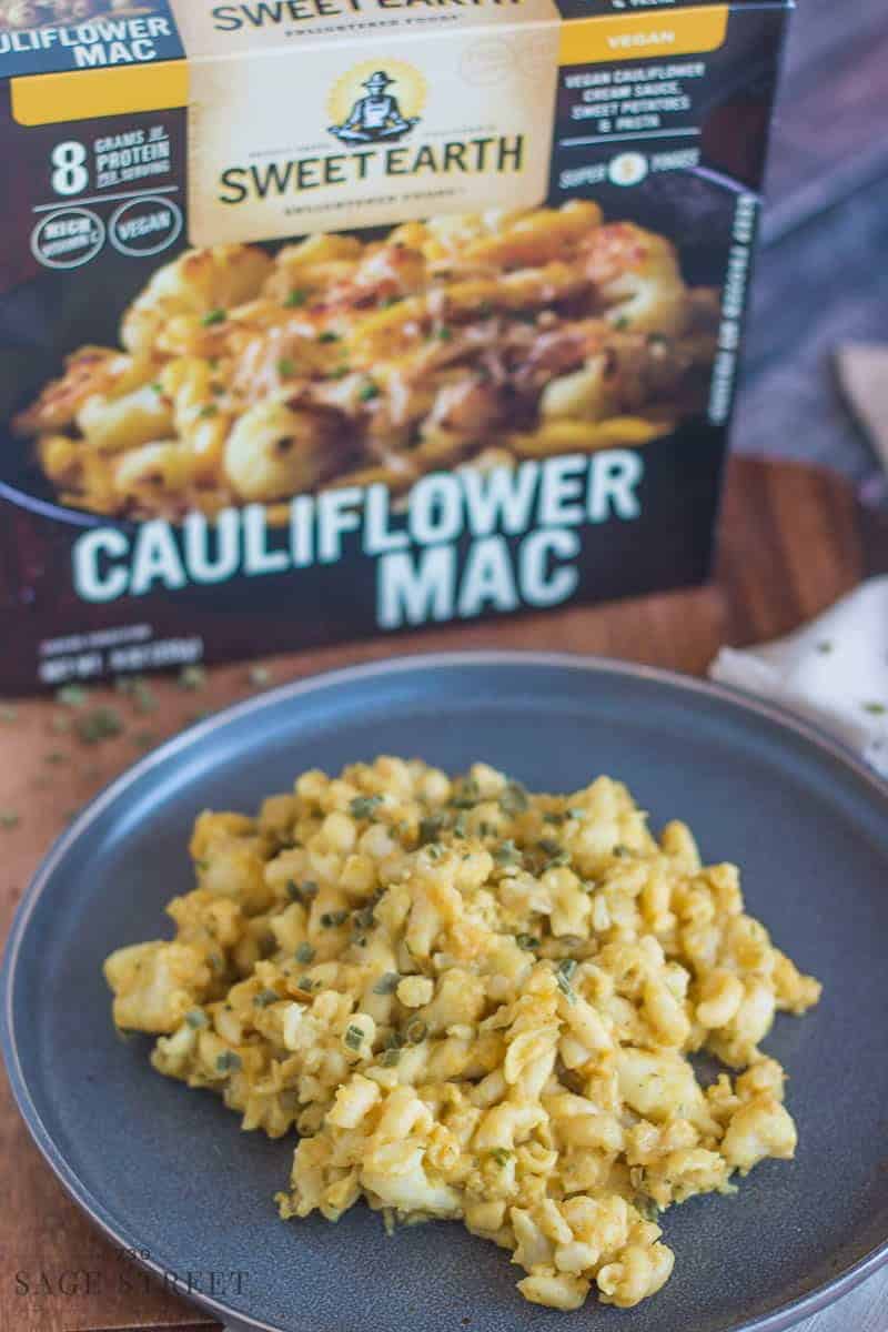 Sweet Earth Foods Cauliflower Mac on a grey plate with the product packaging next to it.