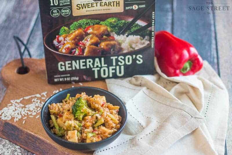 Sweet Earth Foods General TSO's Tofu in a black bowl with the product packaging next to it.