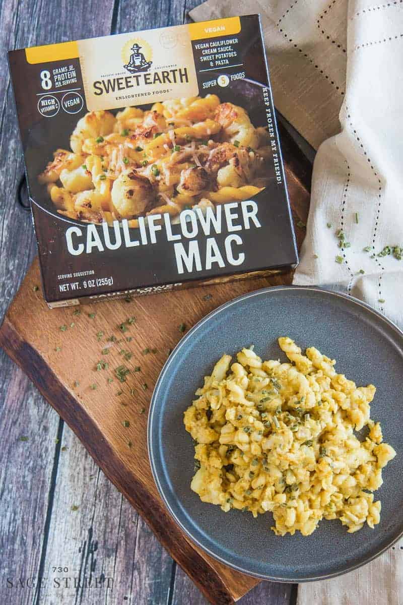 Sweet Earth Foods Cauliflower Mac on a grey plate with the product packaging next to it.
