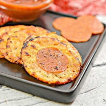 Keto Cheese Crisps 8 keto cheese crisps on a black plate