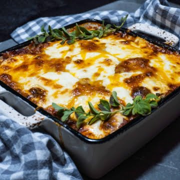 Out of the oven this delicious Keto Lasagna in white and blue stoneware baking dish.