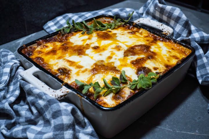 Out of the oven this delicious Keto Lasagna in white and blue stoneware baking dish.