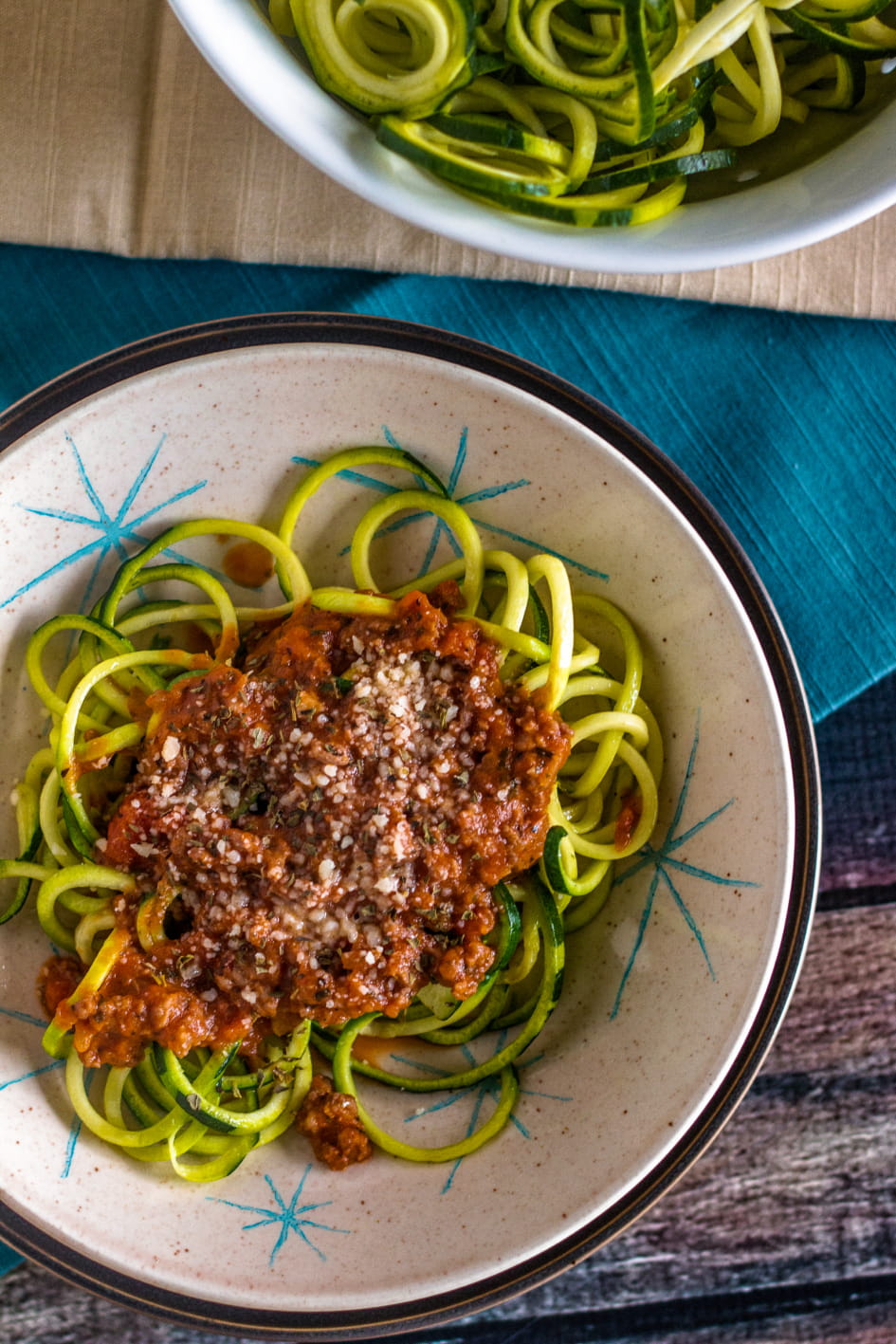 Easy Zucchini Pasta With Bolognese Sauce 2 Final plate of zucchini spirals topped with bolognese sauce in a bowl viewed from the top down.