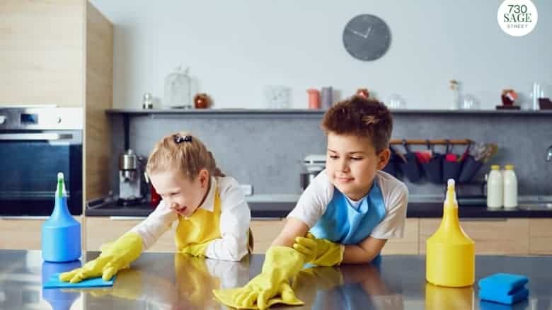 Two school aged children helping with chores, cleaning kitchen table