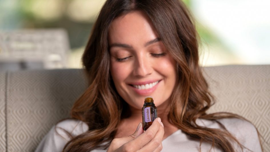 Woman smelling lavender essential oil by doterra