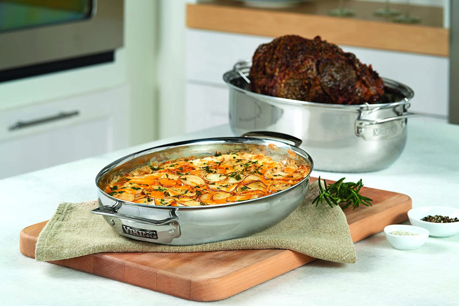 Viking oval roasting pan with bottom round roast, induction lid with scalp potatoes resting on wood cutting board.