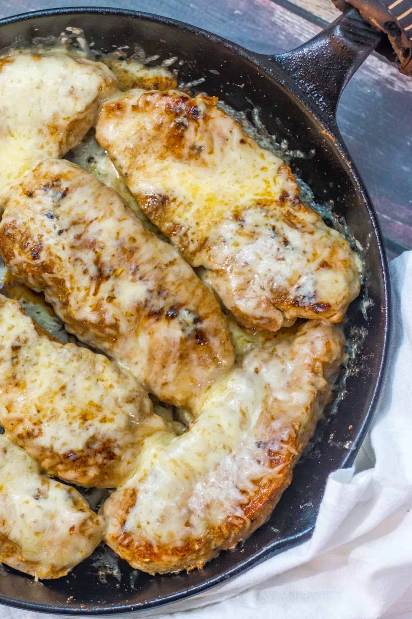 pork chops seasoned with adobo in a cast iron skillet