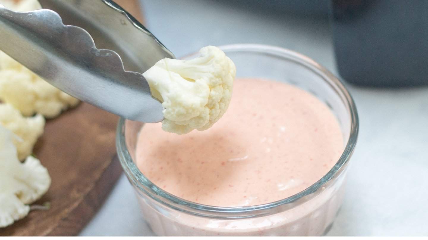 Cauliflower  florets dip into the sauce