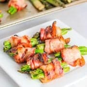 bacon wrapped asparagus served on a white plate