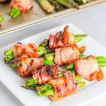 bacon wrapped asparagus served on a white plate