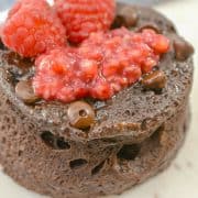 keto chocolate mug cake with raspberries and chocolate chips on top