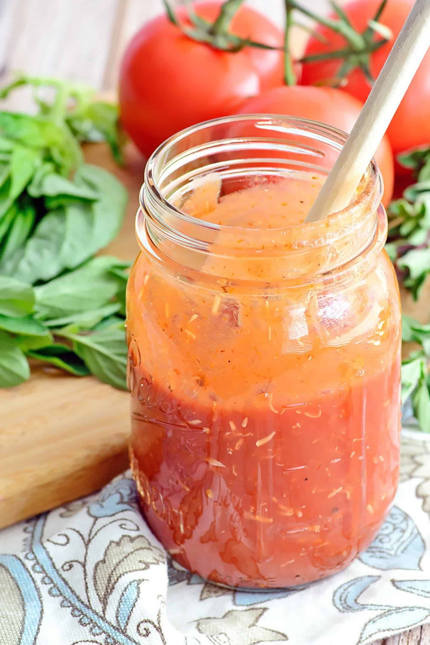 Pizza sauce in a jar with fresh tomatoes