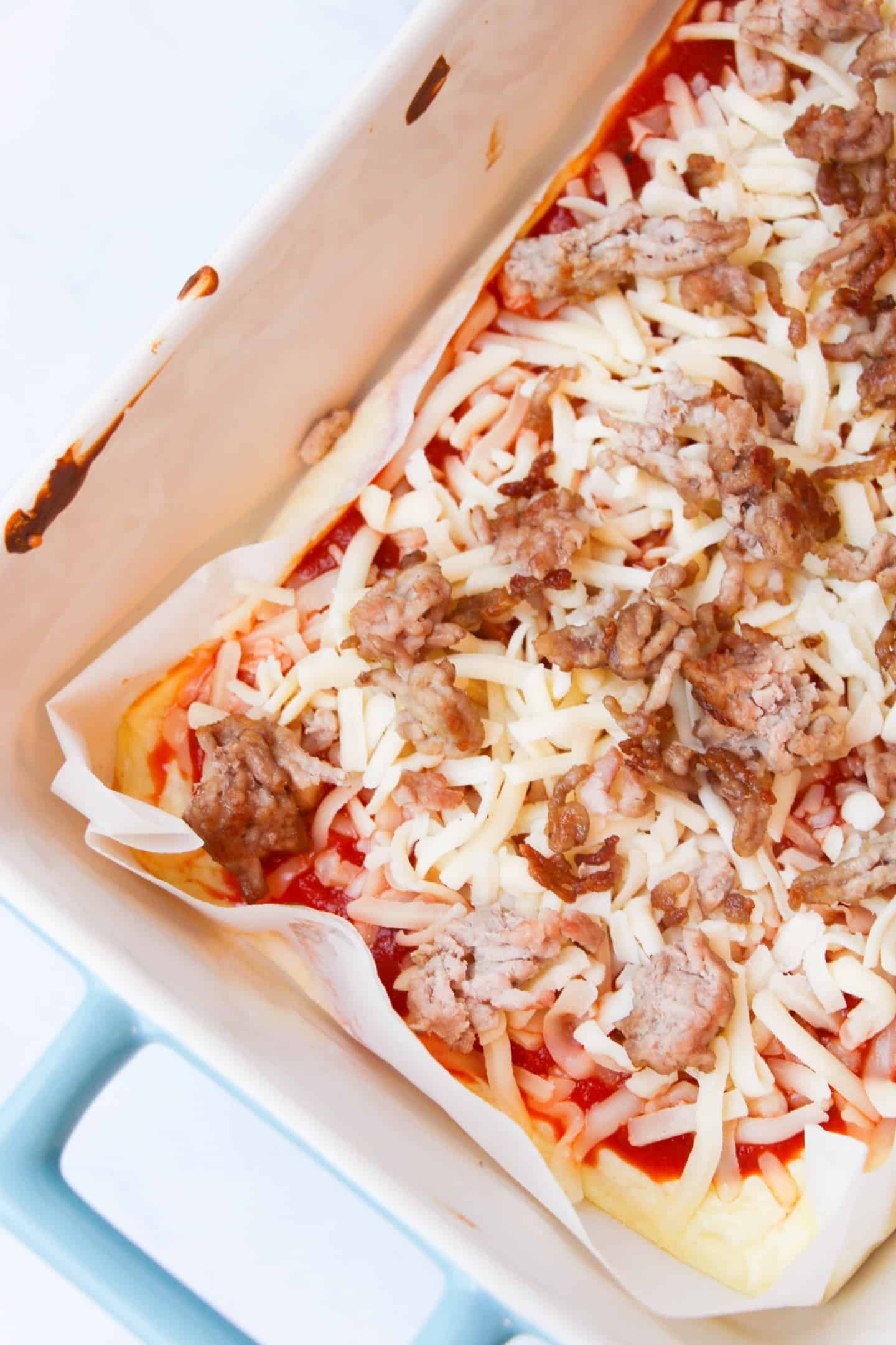 Keto Pizza with italian sausage and cheese in a baking pan
