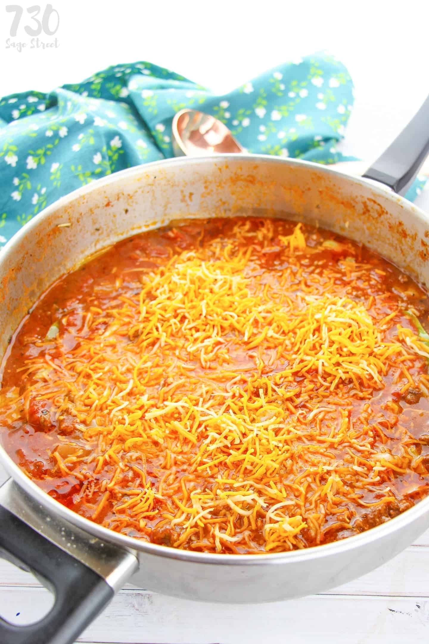 goulash in a pan  with cheedar on a white background