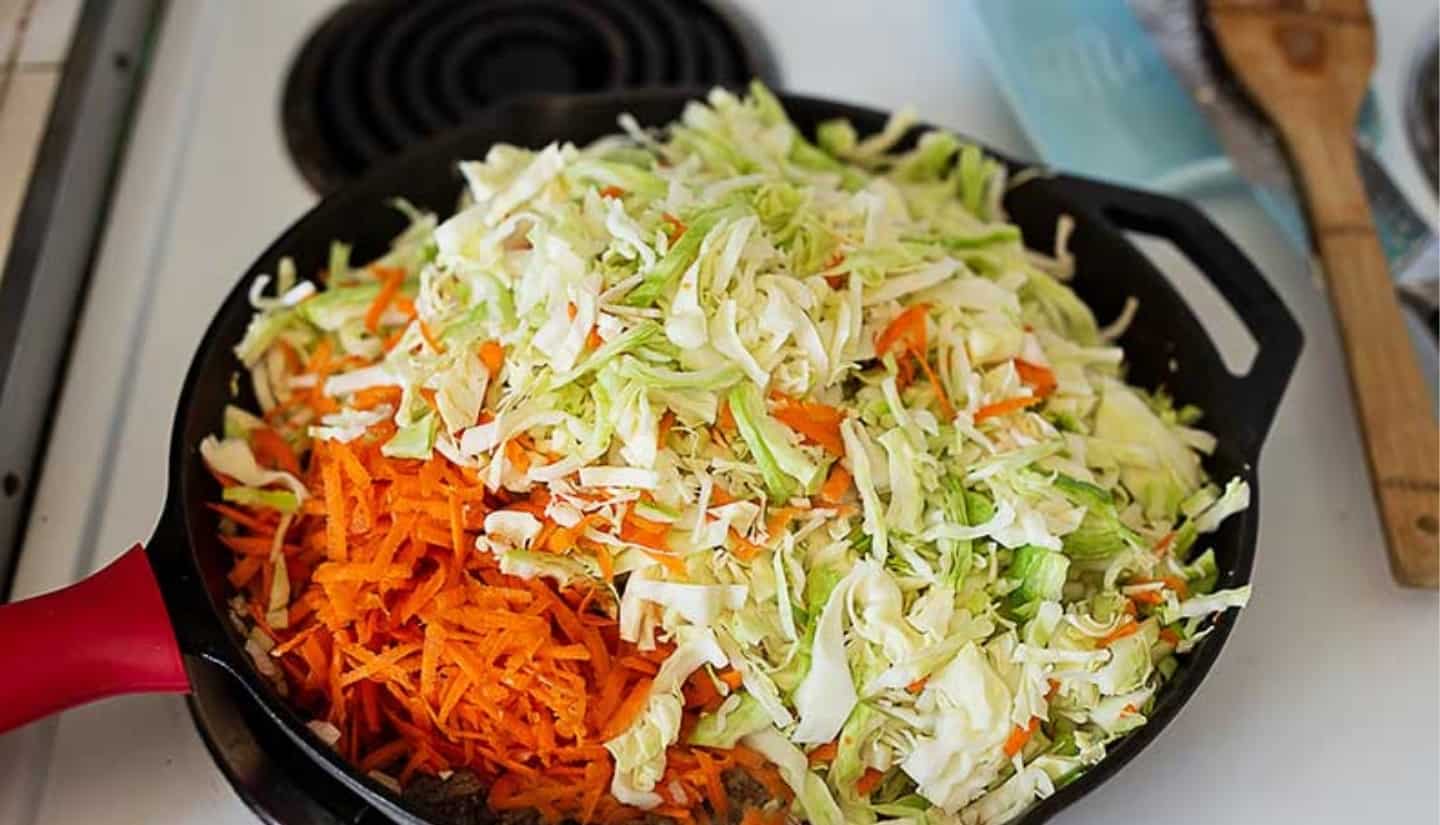 onion meat and garlic on a skillet with vegetables