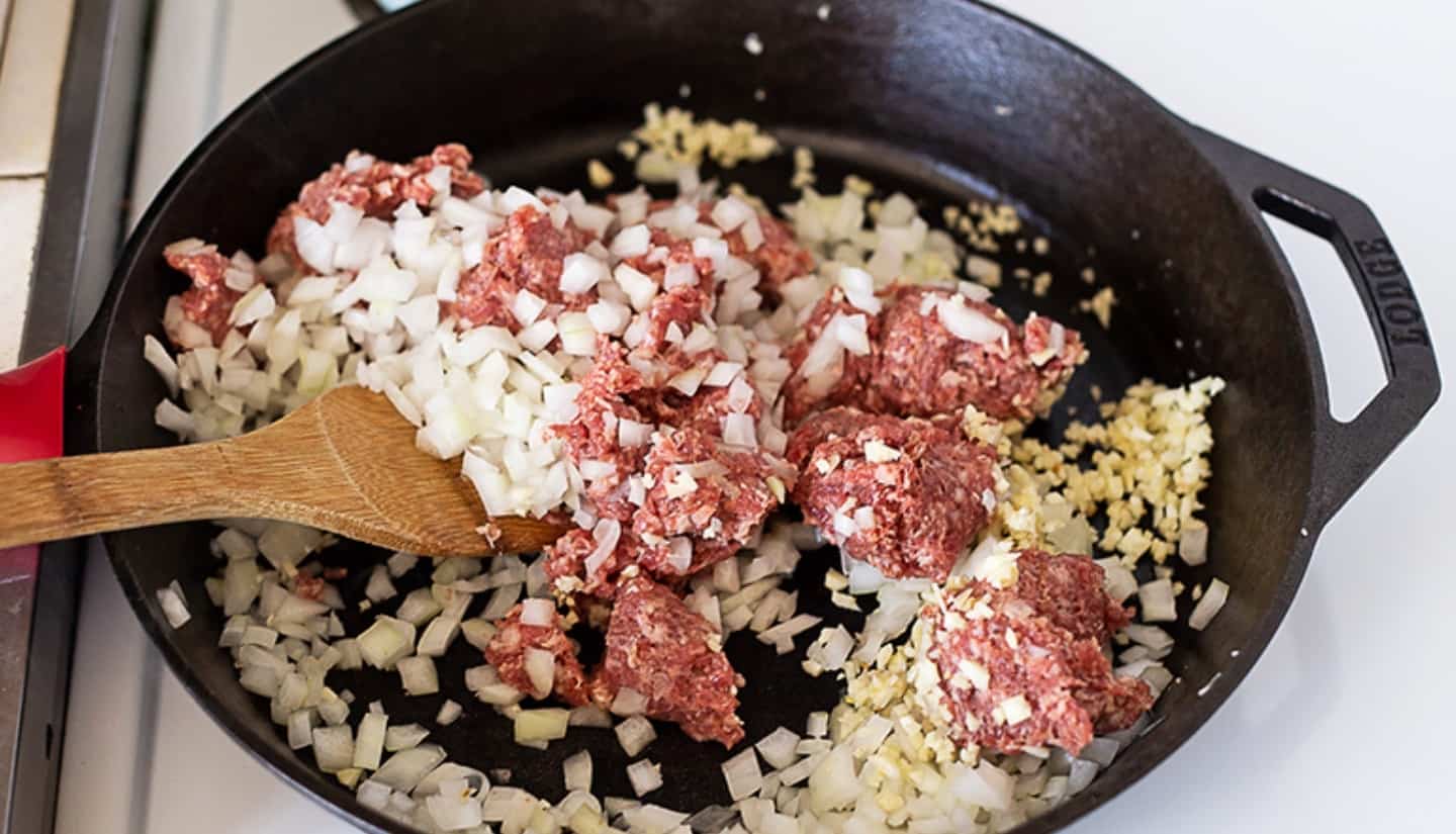 onion meat and garlic on a skillet cooking