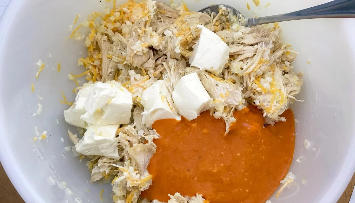 mixing buffalo sauce chicken cheese and cream cheese