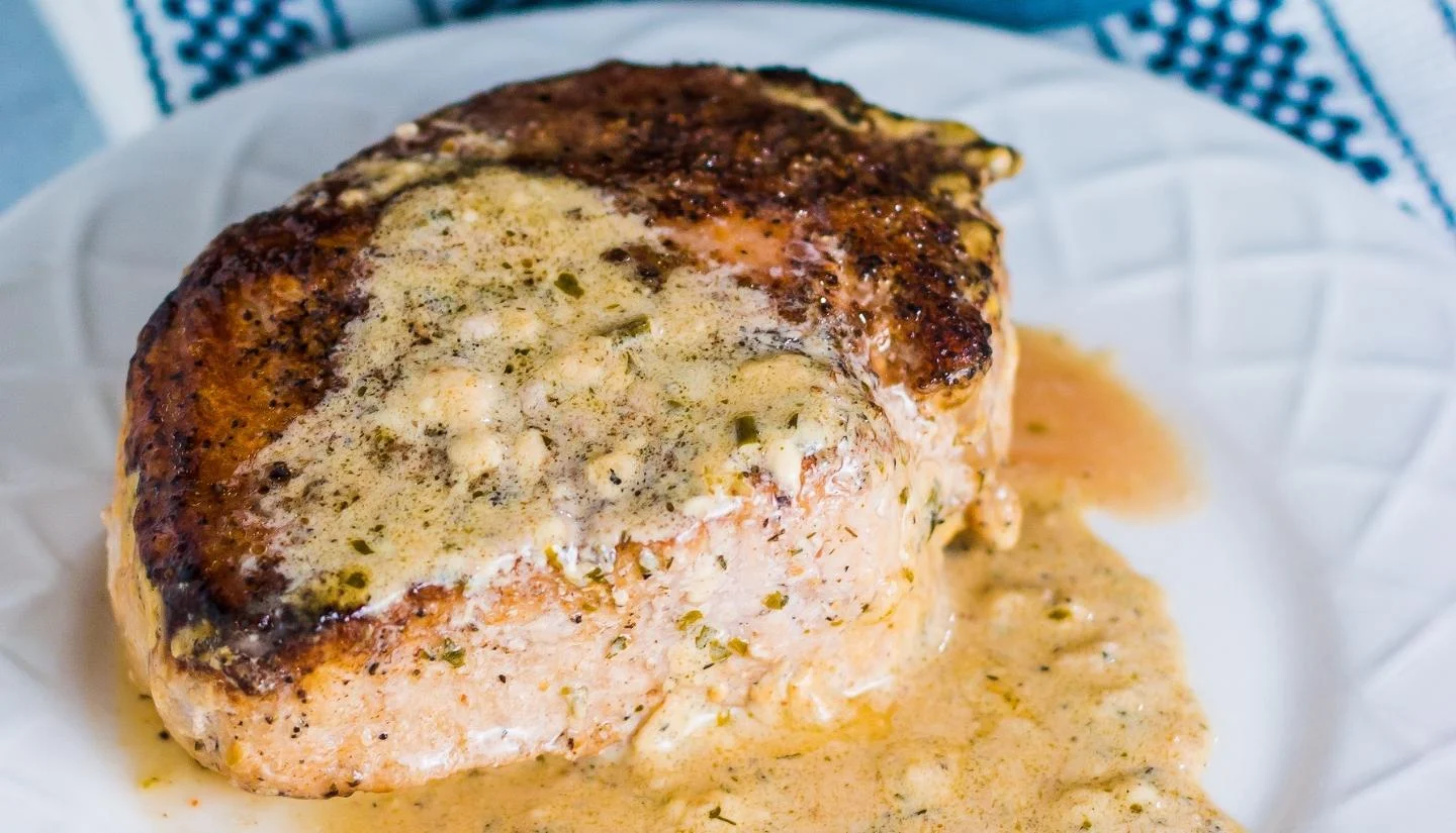 seared pork chop covered in cream cheese sauce