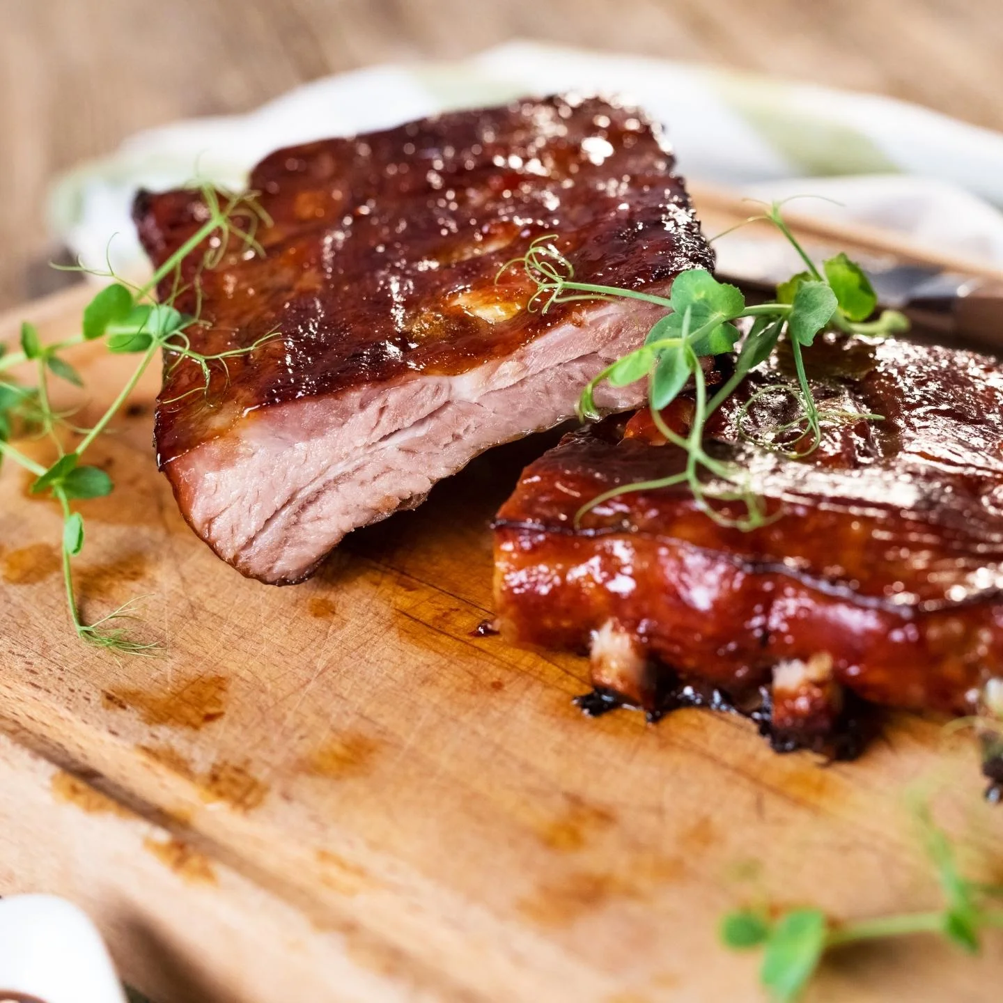 rack of ribs cooked low and slow, covered in homemade bbq sauce and garnished with greens