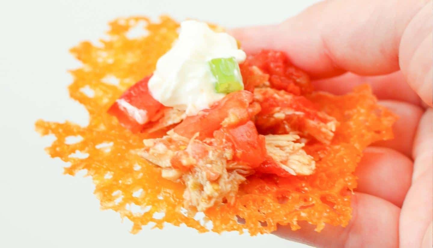 one chicken nachos with tomatoes and sour cream on top