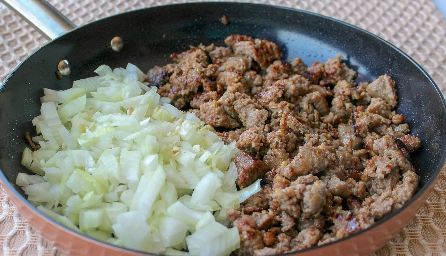 onion and sausage in a pan