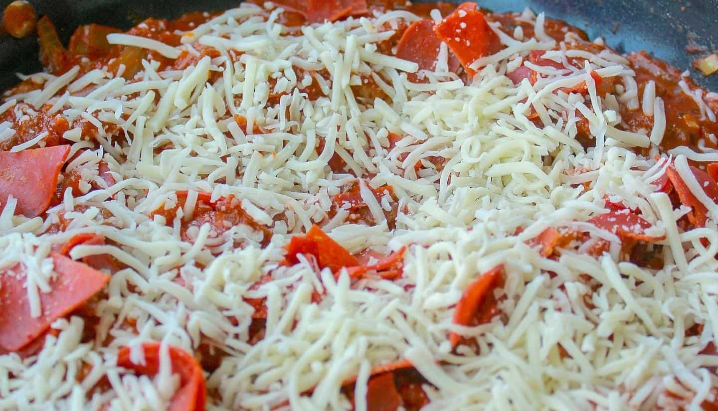 Cheese and pepperoni cooking with the mixture
