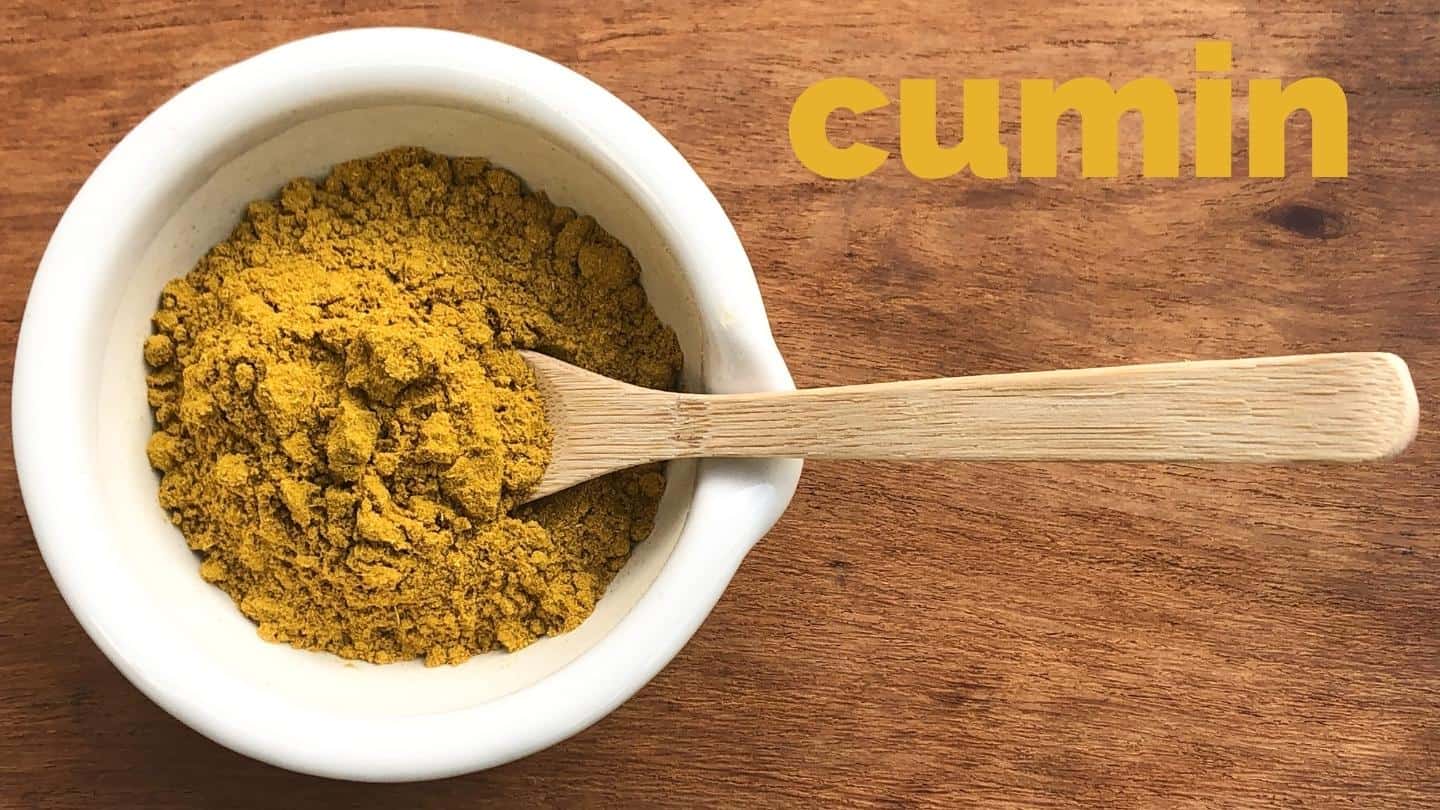 ground cumin in in a white bowl on a spoon