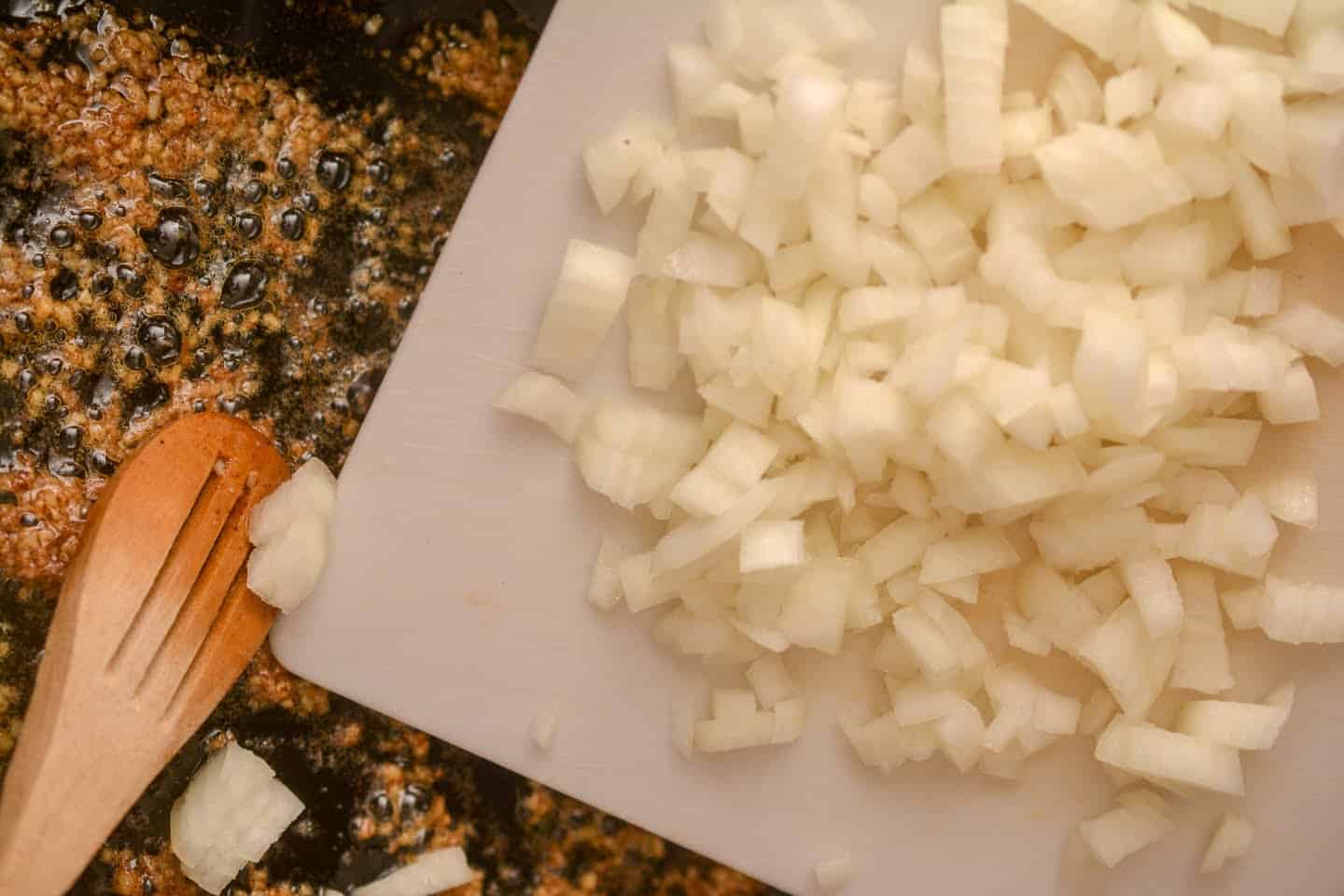 onion on cutting board sliding into butter chicken sauce