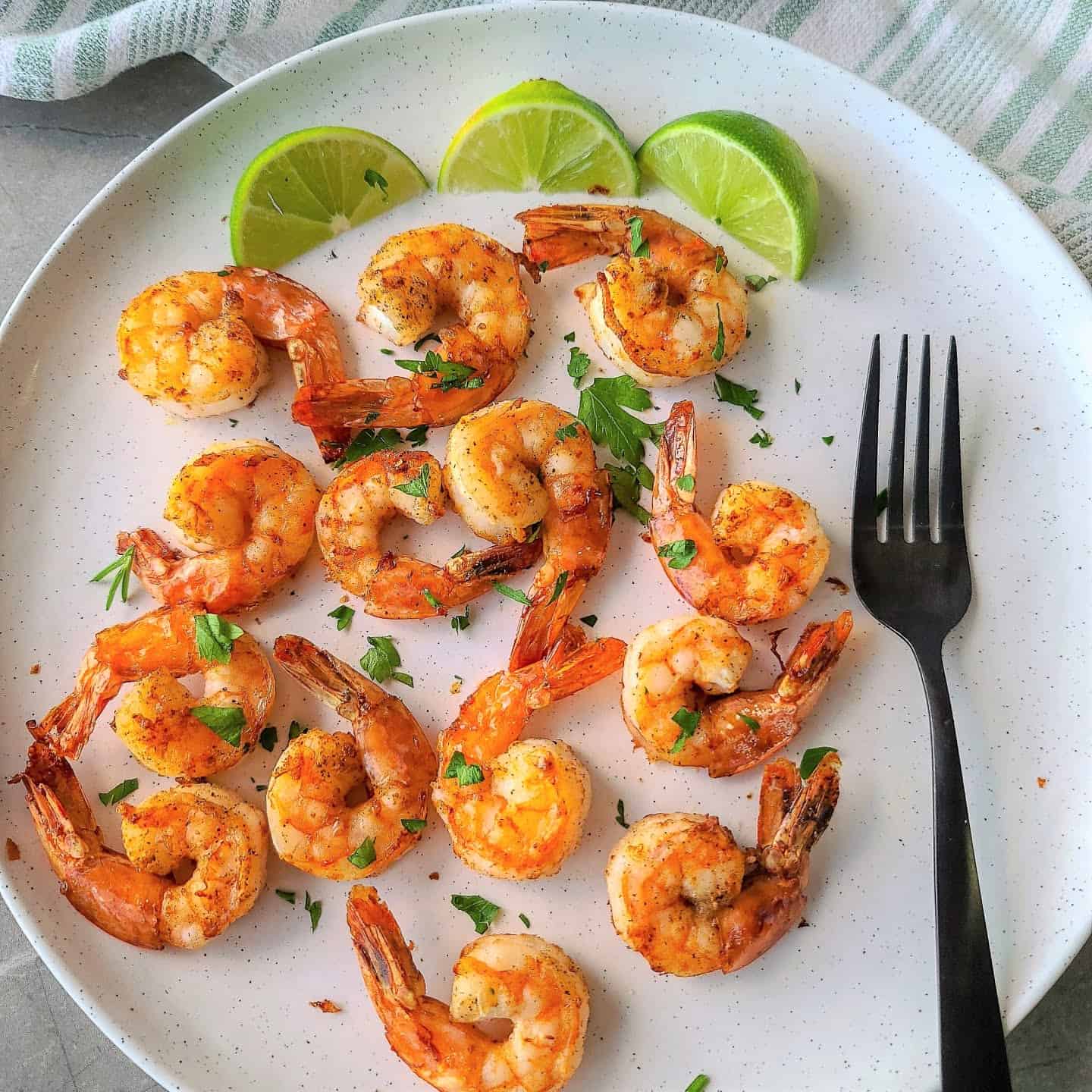 Air fryer shrimps plated with limes