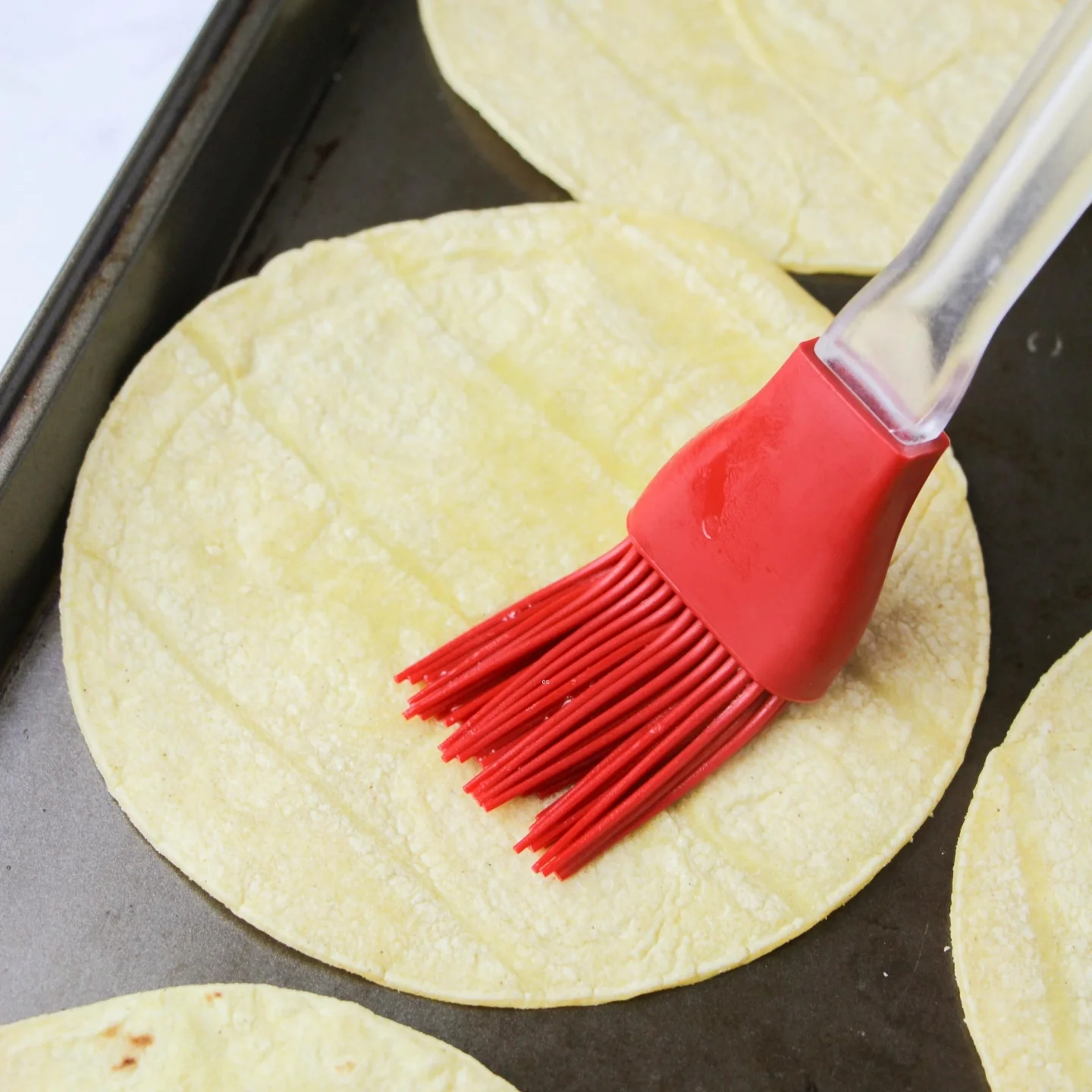 brushing tortillas for enchiladas