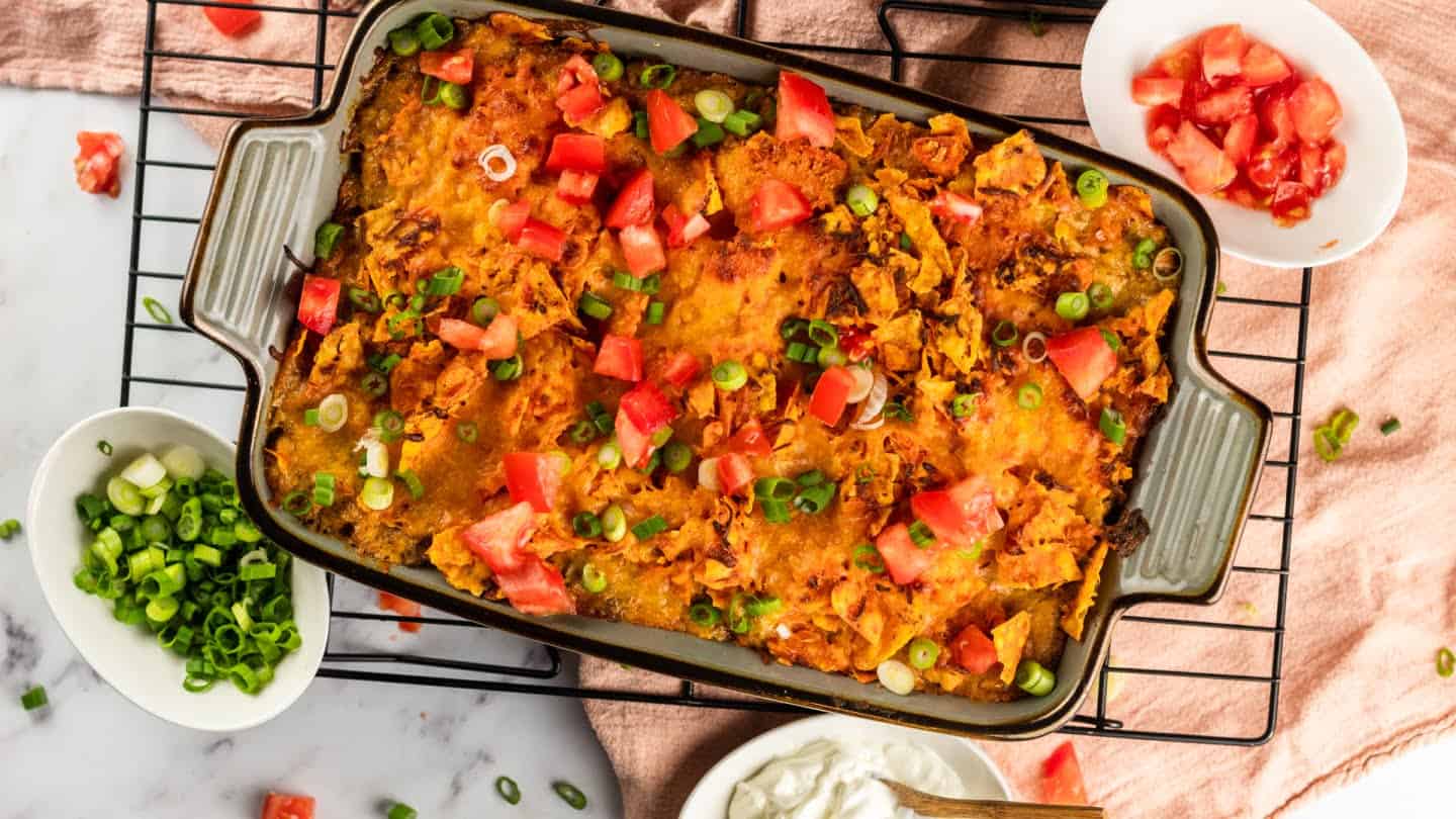 ready to serve Dorito casserole with green onion and tomato garnish