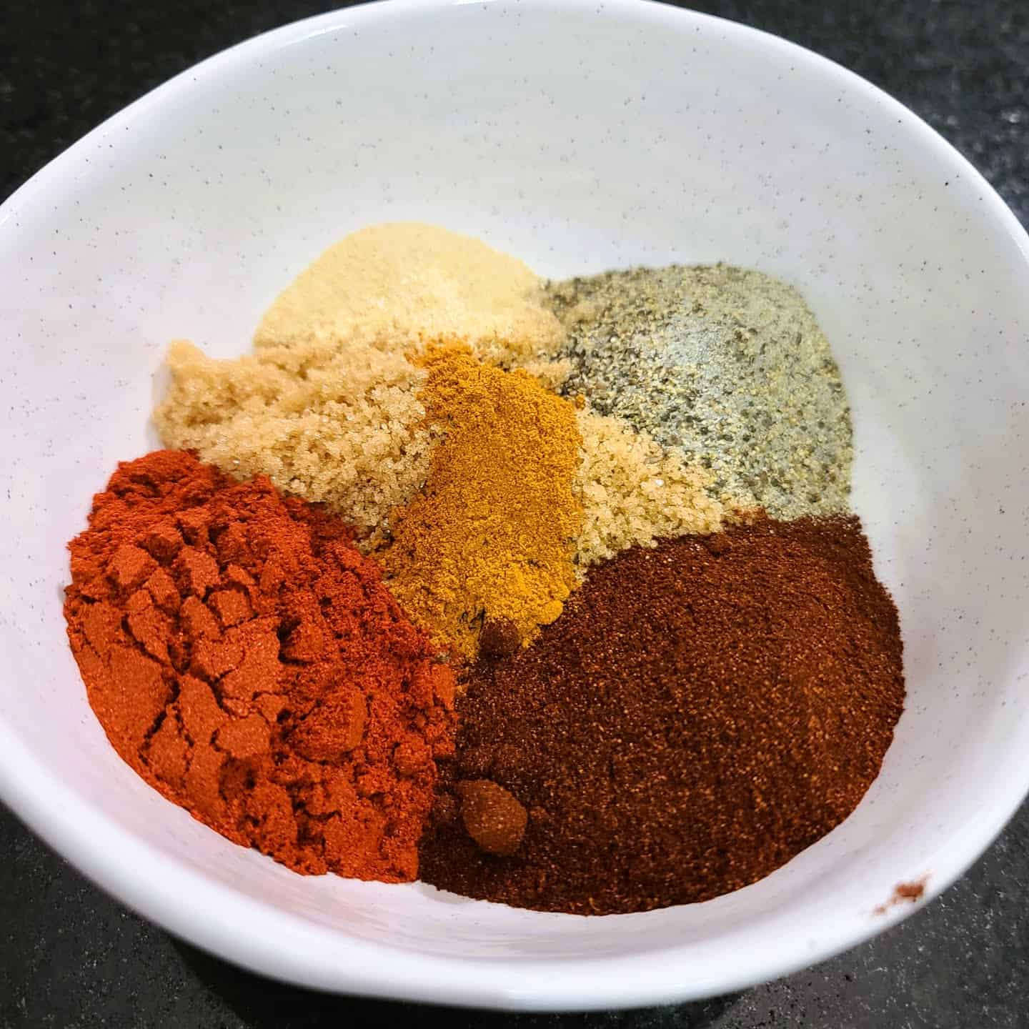 smoked paprika, onion powder, chili powder, cayenne powder, brown sugar, and black pepper.